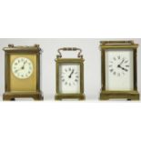 Three manual wind 8 day carriage clocks, brass cased, bevel edged glass panels, enamel dials with