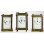 Three manual wind 8 day carriage clocks, brass cased with bevel edge glass panels, white enamel