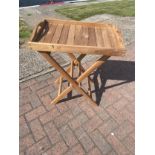 Four untreated teak butlers trays, 60cm x 38cm x 76cm, together with two small picnic tables, 50cm x