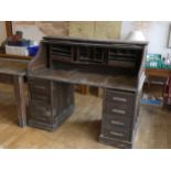 An early 20th century, circa 1920's oak roll top desk, the tambour front opening to an arrangement