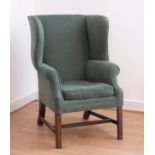 A 19th century mahogany framed wingback armchair upholstered in a dark green chenille fabric, raised