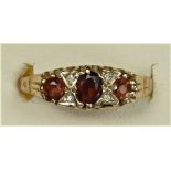 An Edwardian style 9ct rose gold garnet and diamond three stone ring, N, 1.7gm