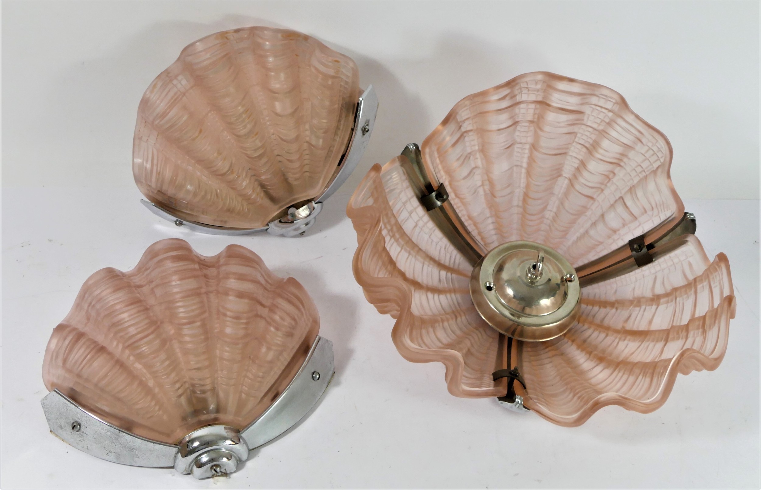 An Art Deco period clam ceiling light, together with a pair of matching wall lights, chrome with