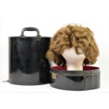 Short, mid brown 1960's style wig in a black patent travel case , 35 x 27cm.