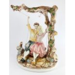 A Capodimonte figure, depicting a couple on a tree swing with a kneeling dog, 43cm x 56cm x 27cm