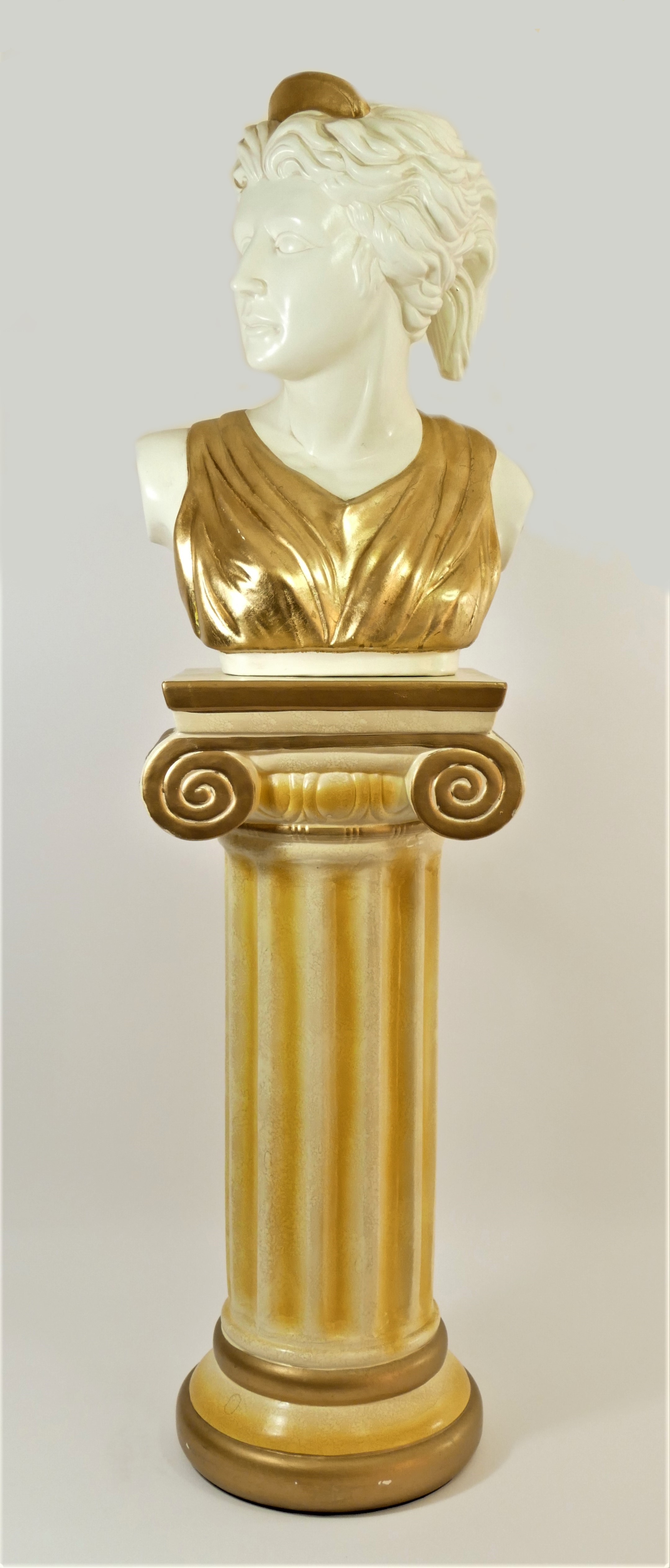 A ceramic bust of a Grecian / Roman female, with gilt head piece and dress, 34cm x 48cm x 26cm, on a