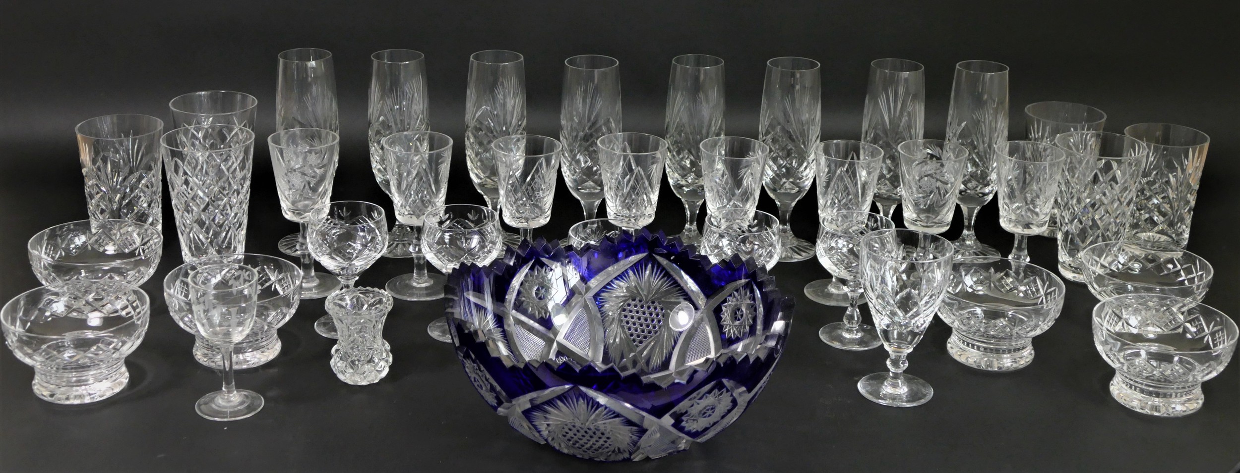 A collection of fine cut glass drinking glasses, together with a cobalt blue cut clear crystal