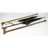 Two Victorian parasols, together with a hazel shafted walking stick and a carved wood ducks head