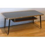 A 1960s/70s 'Atomic' coffee table, black with gold trim having under tier magazine rack, raised on