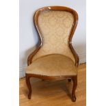 A Victorian style mahogany framed nursing chair, tapestry fabric, the curved side rails extending to