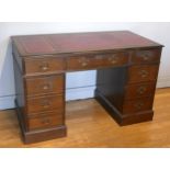 A mahogany kneehole twin pedestal desk, rectangular top with inset leather skiver, above three
