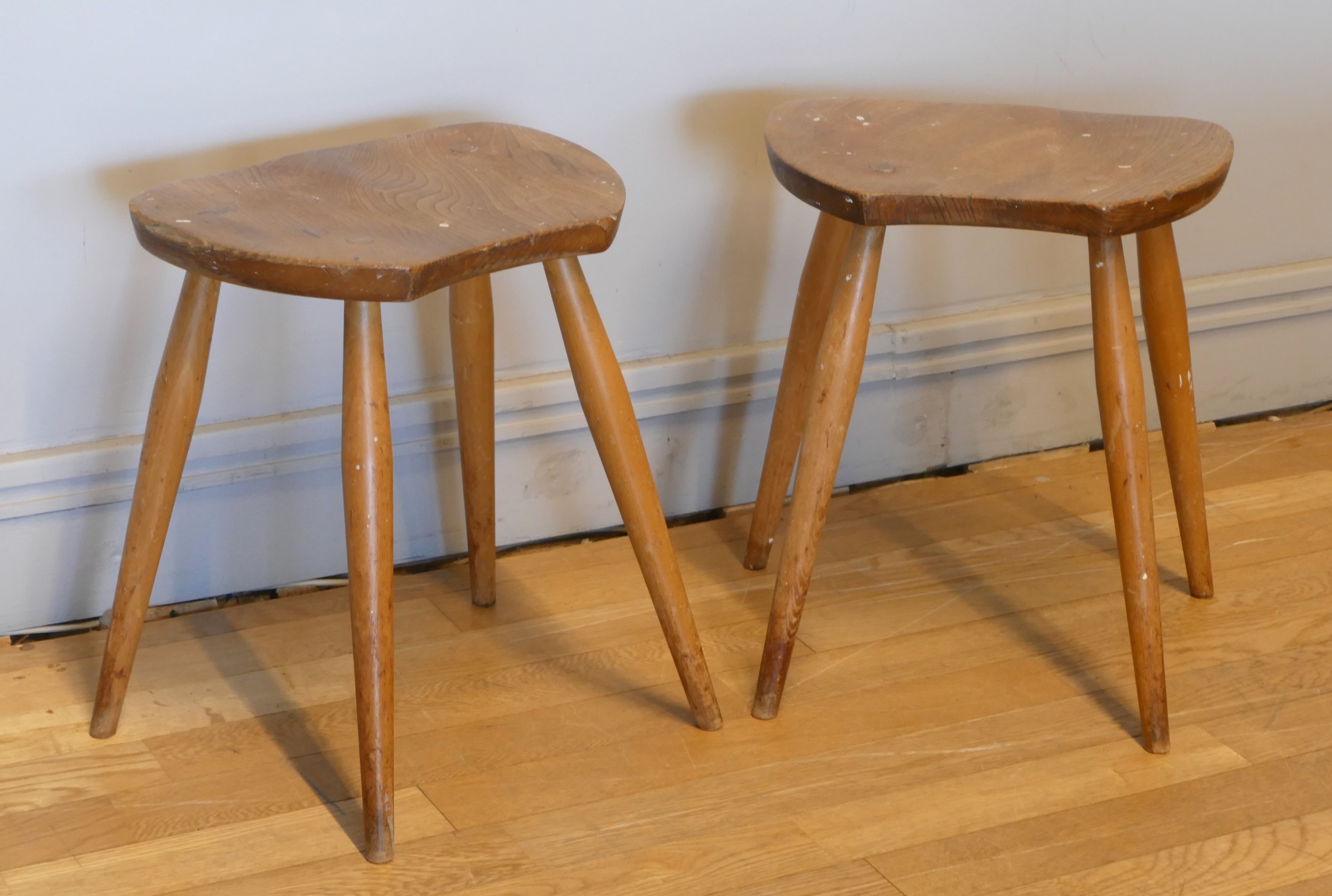 A pair of Ercol Blonde elm and beech saddle stools, c.1960s, stamped to underside - B.S 1960, B.J