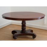 A Victorian oval mahogany tilt top table with thumb nail edging, raised on a turned pedestal to a