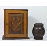A late Victorian smokers cabinet, having carved panel door enclosing a fitted interior,