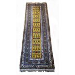 A Turkish Konya runner, with guls on a yellow field, multi layered border, 295 x 85cm. Sold with a