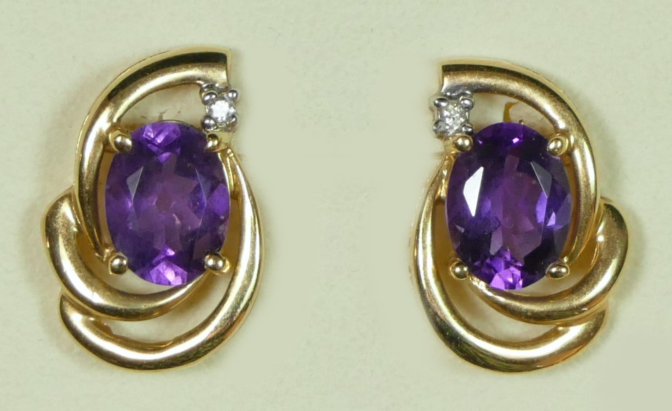 A 9ct gold pair of amethyst and diamond scroll ear studs, 3.6gm