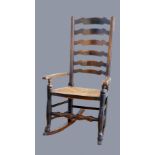 An 18th century oak ladder back rocking chair, with rush seat