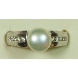 A 9ct white gold cultured pearl and diamond dress ring, channel set with brilliant cut stones, P.
