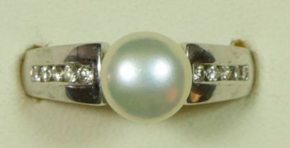 A 9ct white gold cultured pearl and diamond dress ring, channel set with brilliant cut stones, P.
