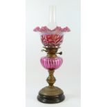 A late Victorian oil lamp, with etched cranberry glass shade, floral decoration, clear glass