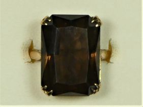 A 9ct gold and smokey quartz vintage dress ring, Birmingham 1966, claw set with a step cut stone, 18