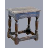 A 17th century oak joint stool, with plank top and thumb nail edge, line incised frieze, on turned