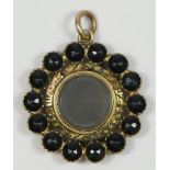 A Georgian gold and facetted jet/black onyx mourning locket pendant, with engine turned decoration
