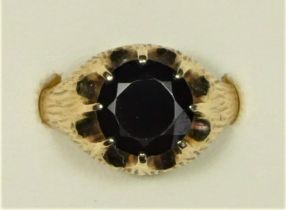 A 9ct gold and garnet single stone ring, by J.S. Ltd., London 1976, with textured shank, diameter