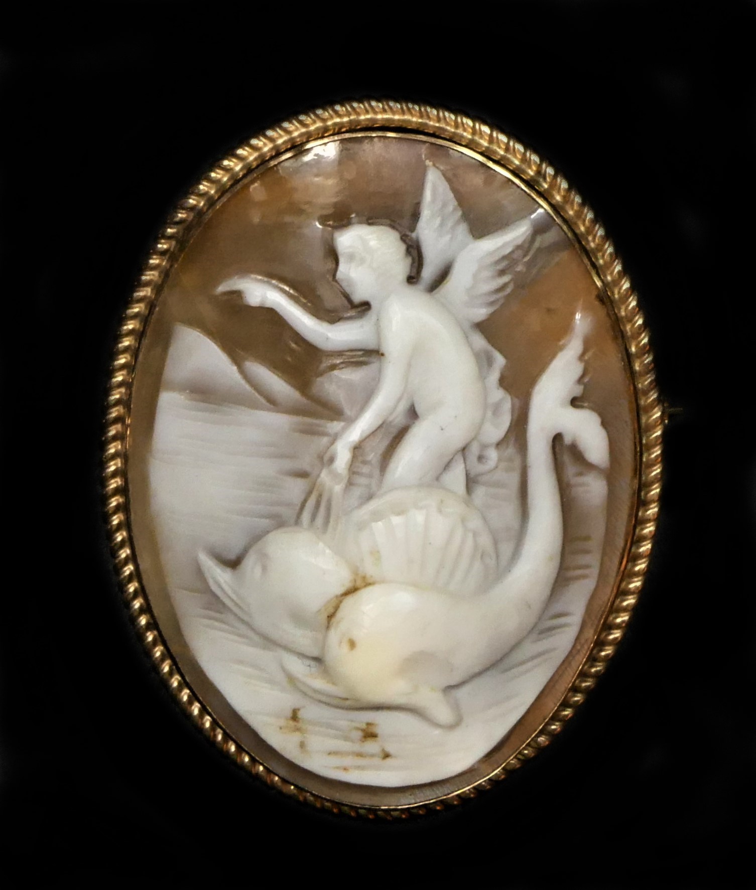 A gold mounted shell cameo, carved to depict Arion riding a dolphin, 43 x 33mm. This subject is