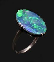 A white metal mounted black opal doublet ring, c.1920/30, the oval stone with good colour play, 18 x