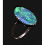 A white metal mounted black opal doublet ring, c.1920/30, the oval stone with good colour play, 18 x