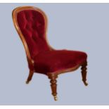 A Victorian mahogany framed nursing chair, having spoon button back, upholstered in a burgundy