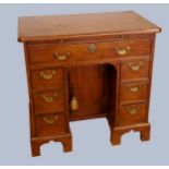 A George III mahogany kneehole desk, with shaped top over a single frieze drawer, the central