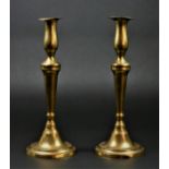 A pair of George III brass candlesticks, of baluster form, stepped foot, candle pushers to the base,