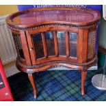 A rosewood kidney shaped display cabinet with bevelled glass panels raised on cabriole legs, lift