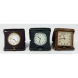 Three 1920s traveling bedside clocks, 8 day Swiss movements mounted on folding leather cases. (3)
