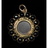 A Georgian gold and facetted jet/black onyx mourning locket pendant, with engine turned decoration