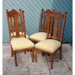 An Art Nouveau set of four mahogany dining chairs, with floral carved top rail, tapering legs,