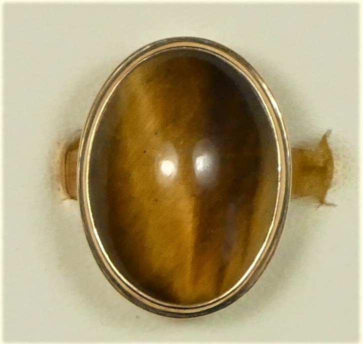 A 14K gold and tigers eye dress ring, collet set with a cabochon stone, 19 x 14mm, J, 6.1gm