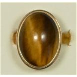 A 14K gold and tigers eye dress ring, collet set with a cabochon stone, 19 x 14mm, J, 6.1gm