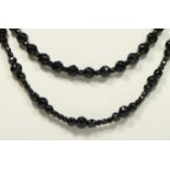 A facetted French Jet glass bead necklace, and another similar, both 70cm (2)