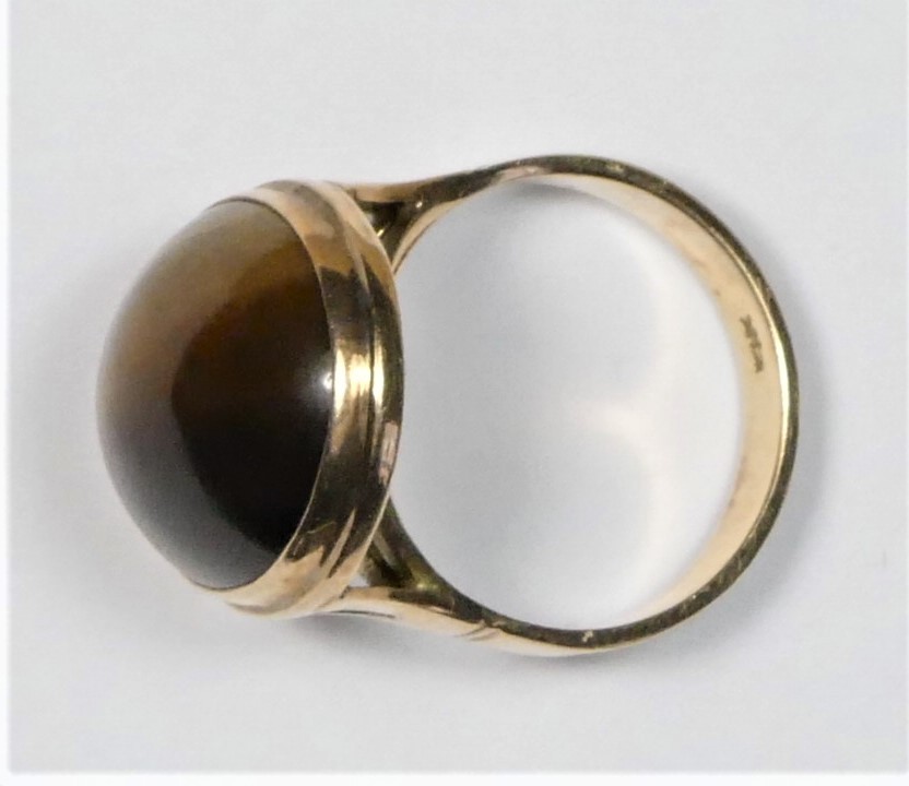 A 14K gold and tigers eye dress ring, collet set with a cabochon stone, 19 x 14mm, J, 6.1gm - Image 2 of 2