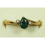 A 10k gold emerald and diamond three stone ring