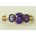 A 9ct gold three stone amethyst ring, good colour stones, W, 2.8gm