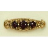 A 9ct gold three stone garnet ring, O, 2.7gm