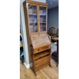 An Art Deco oak bureau bookcase, the glazed doors over a fall front, lower fold out magazine rack,