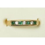 A 9ct gold emerald and brilliant cut diamond channel set ring, L 1/2, 2g.