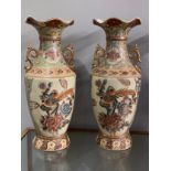 A pair of satsuma style vases depicting peonies and birds with a peach background, one with some