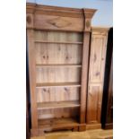 A waxed pine five shelf book case with moulded side panels, 109 x 38 x 207cm and a waxed pine two