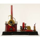 A Marklin style horizonal boiler live steam stationary engine, of tin plate construction, red and